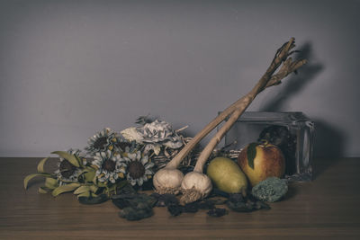 Vegetables with fruits and herbs on table against wall