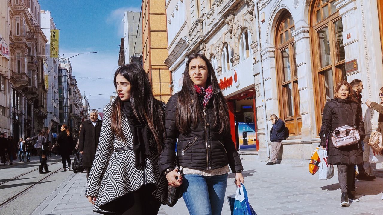 architecture, city, building exterior, built structure, young adult, young women, lifestyles, real people, looking at camera, street, women, casual clothing, day, leisure activity, three quarter length, people, incidental people, standing, front view, portrait, outdoors, beautiful woman, teenager