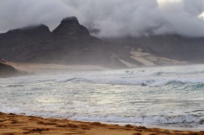 Scenic view of sea and mountains against sky