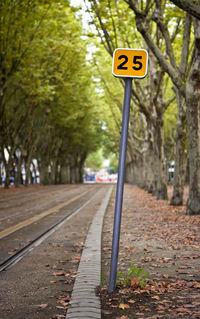 Road sign by railroad track