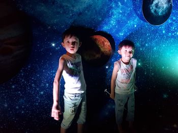 Boys standing against space pattern wall