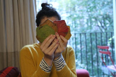 Young woman covering face with home