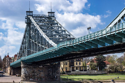 Low angle view of bridge against cloudy sky