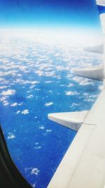 Cropped image of airplane wing over landscape