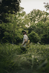 Man standing on field against trees