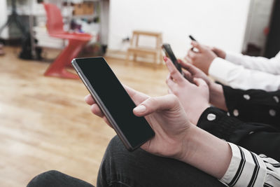 Midsection of man using mobile phone