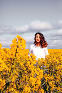 Woman with yellow flowers on field