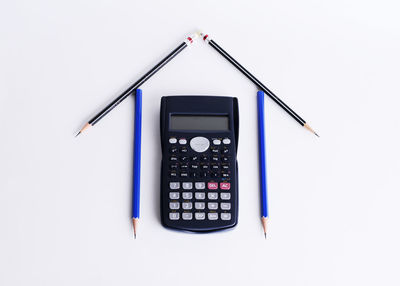 High angle view of calculator and pencil against white background