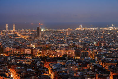 Illuminated cityscape against clear sky at night