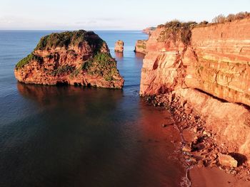 Rock formations in sea against sky