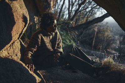 Girl sitting on tree trunk