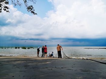 People on beach against sky