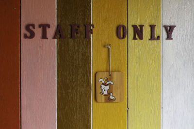 Close-up of restroom sign on wooden door