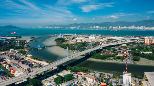 High angle view of city by sea against sky