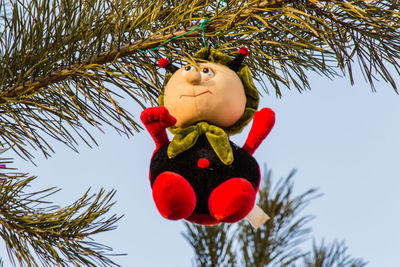 Low angle view of toy hanging on christmas tree