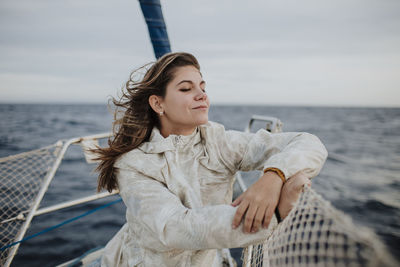 Young woman looking at sea shore against sky