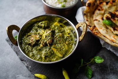 Homemade palak chicken or saag chicken served with butter naan bread and rice