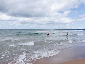 People on beach against sky