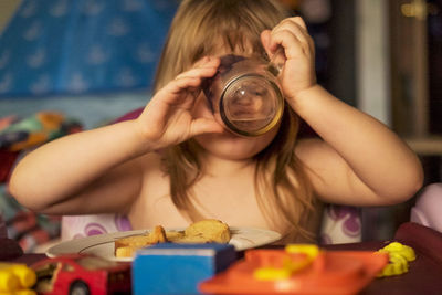 Shirtless girl drinking water at home