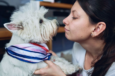 Midsection of woman with dog at home