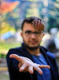 Portrait of young man holding leaf