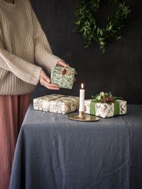 Midsection of woman holding ice cream on table