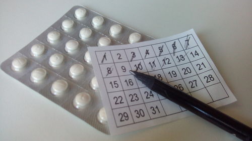 Close-up of medicines with numbers and pen on table