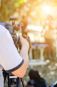 Cropped hand of man operating television camera