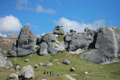 Rocks on landscape against cloudy sky