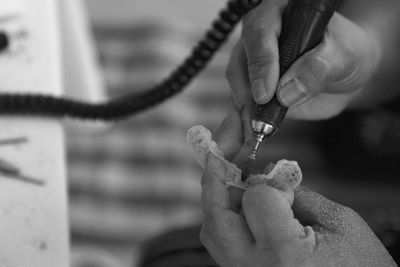 Cropped hands of person making braces