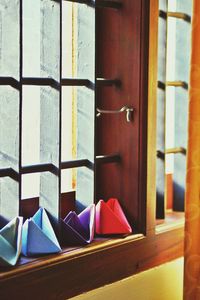 Close-up of colorful paper boats on window sill