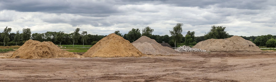 Stack of rocks on field against sky