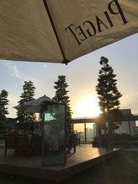 Information sign by swimming pool against sky at sunset