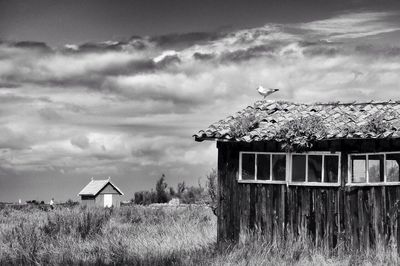 House on field against cloudy sky