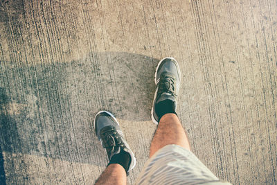 Low section of man standing on wooden floor