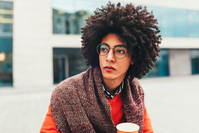 Thoughtful young man with afro hairstyle in city