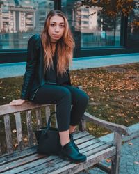 Portrait of young woman sitting on bench