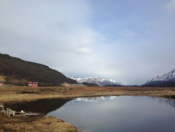 Scenic view of lake by mountains against sky