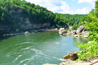 Scenic view of river against cloudy sky