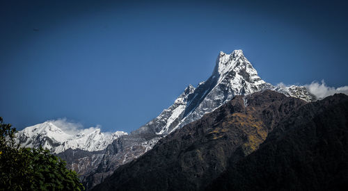 Scenic view of snowcapped mountains against clear blue sky