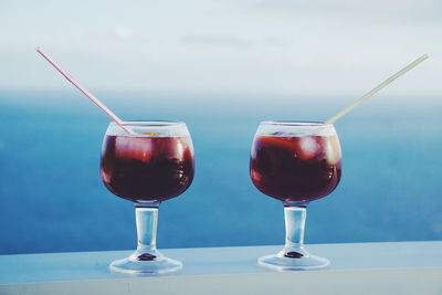 Close-up of drink on table against sea