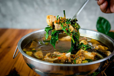 Close-up of hand holding food in bowl