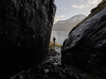 Woman hiking along oceanside trail in the faroe islands