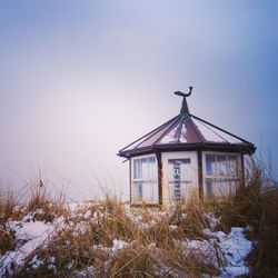 House on field against sky during winter