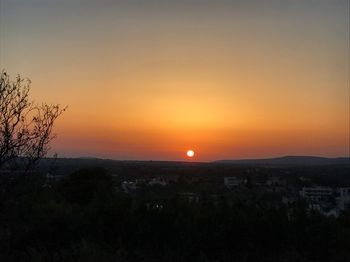 Scenic view of silhouette landscape against orange sky