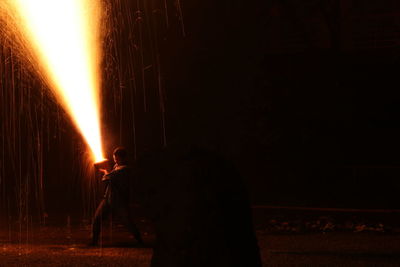 Rear view of man standing in city at night