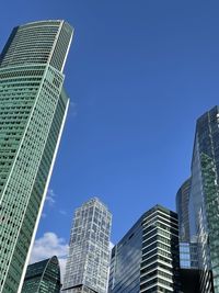 Low angle view of modern buildings against clear blue sky