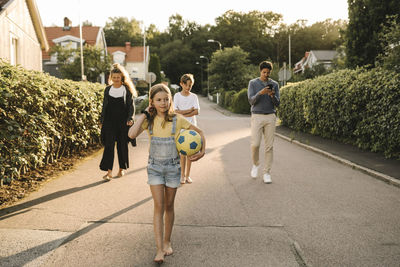 Children walking with parents on road