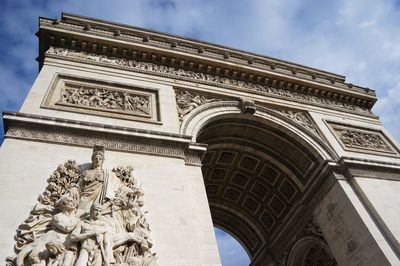 Low angle view of historical building against cloudy sky, paris france 