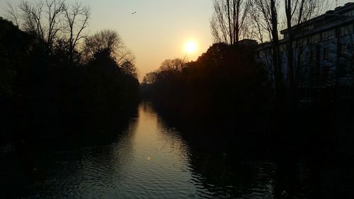 Scenic view of river against sky at sunset